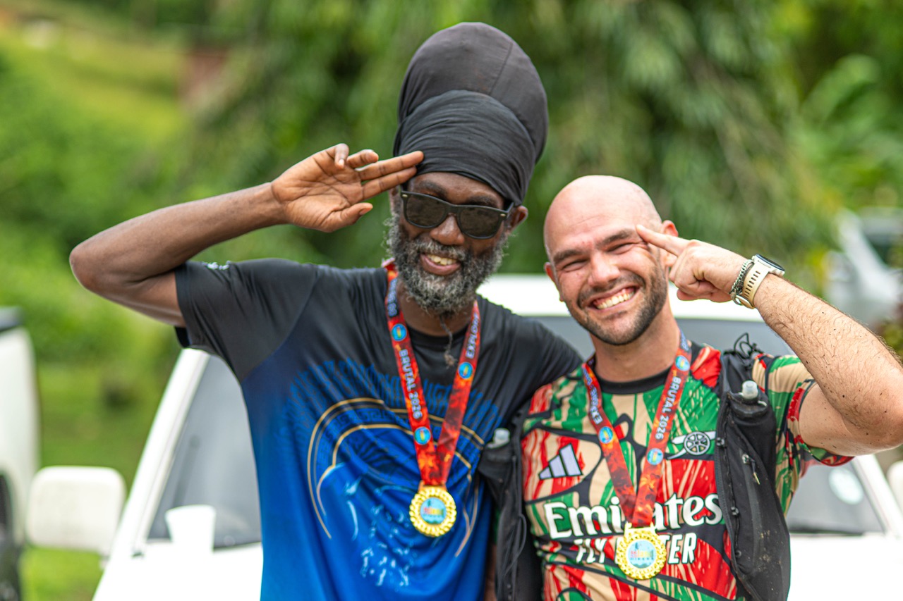 Two finishers saluting with their medals on