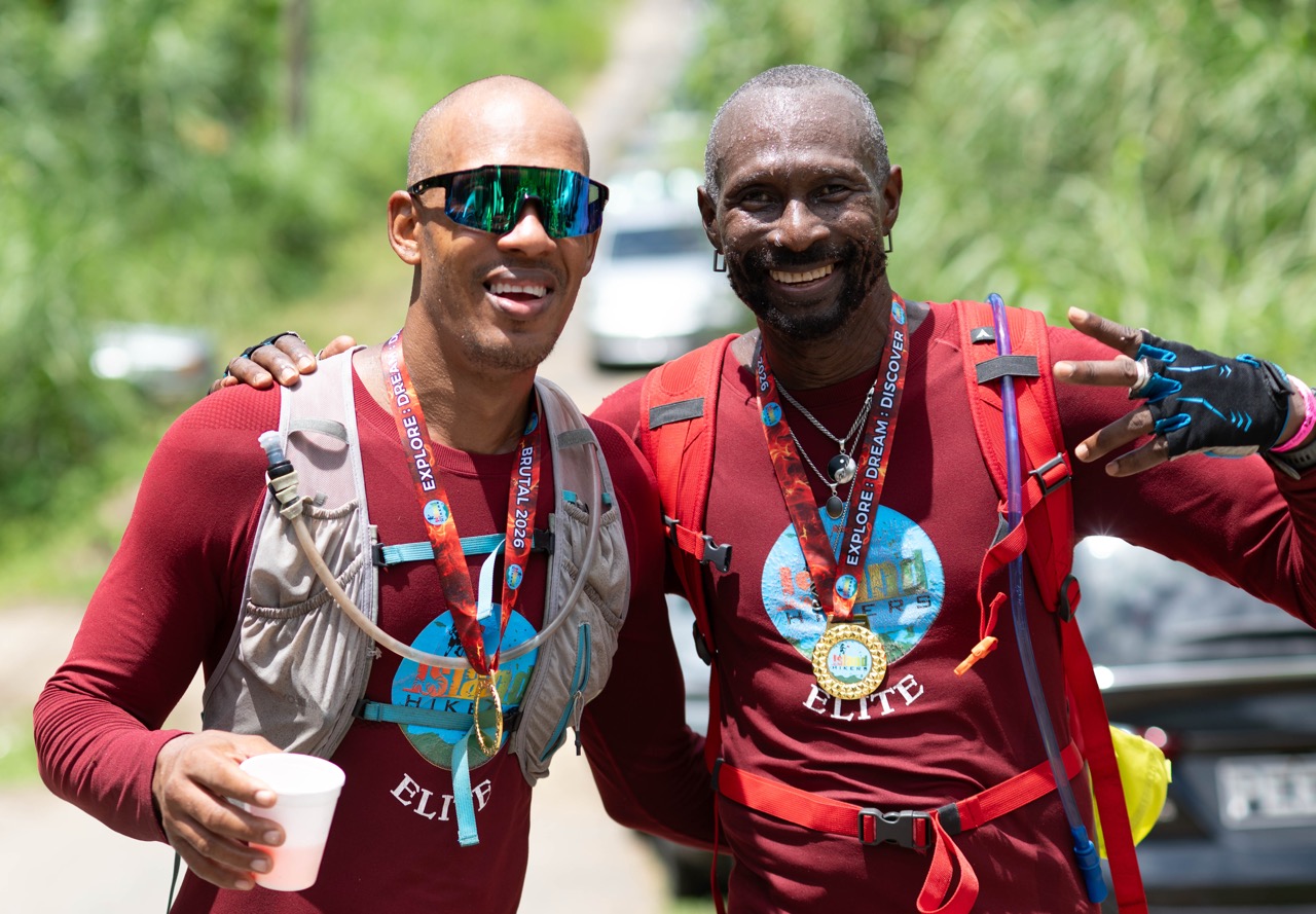 Two finishers in red Elite shirts showing their medals