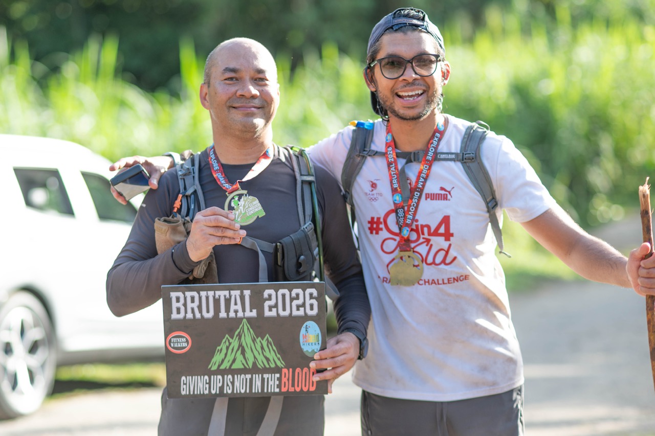 Two finishers with the Brutal 2026 sign
