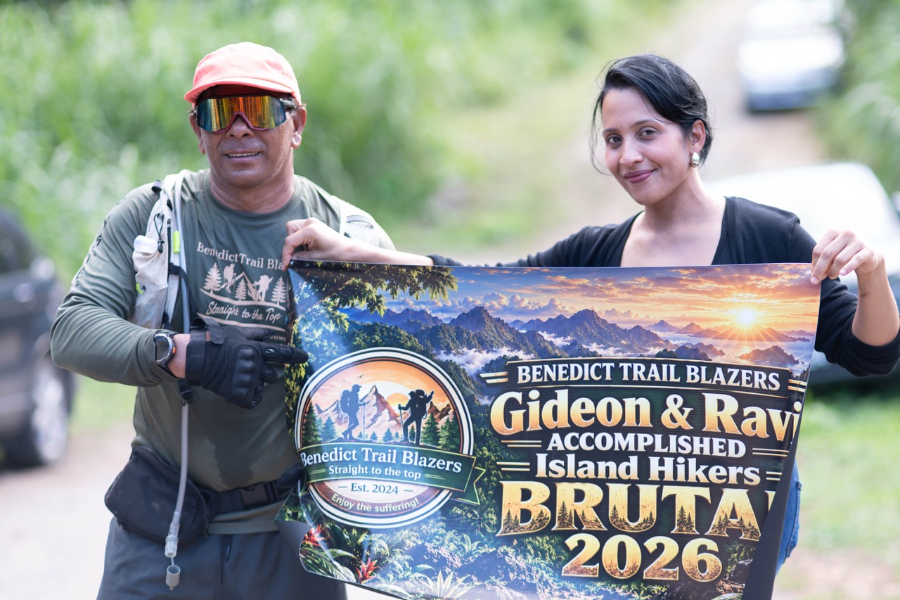 Two hikers holding a Benedict Trail Blazers Brutal 2026 banner