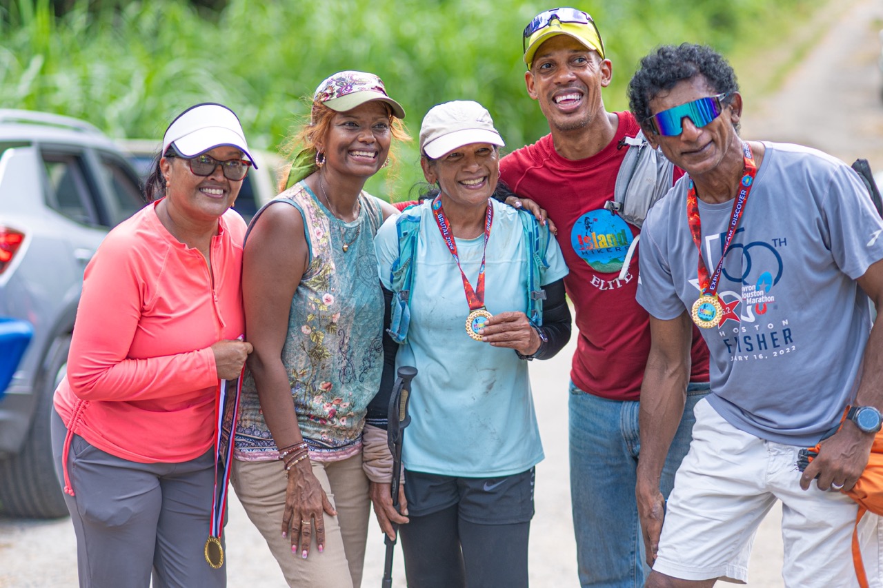 Five finishers standing together with their medals